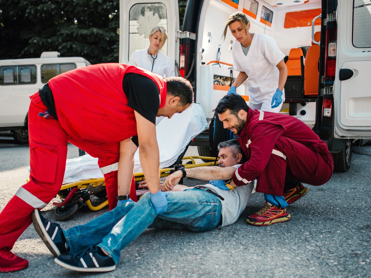 Medical emergency team helping injured mature man